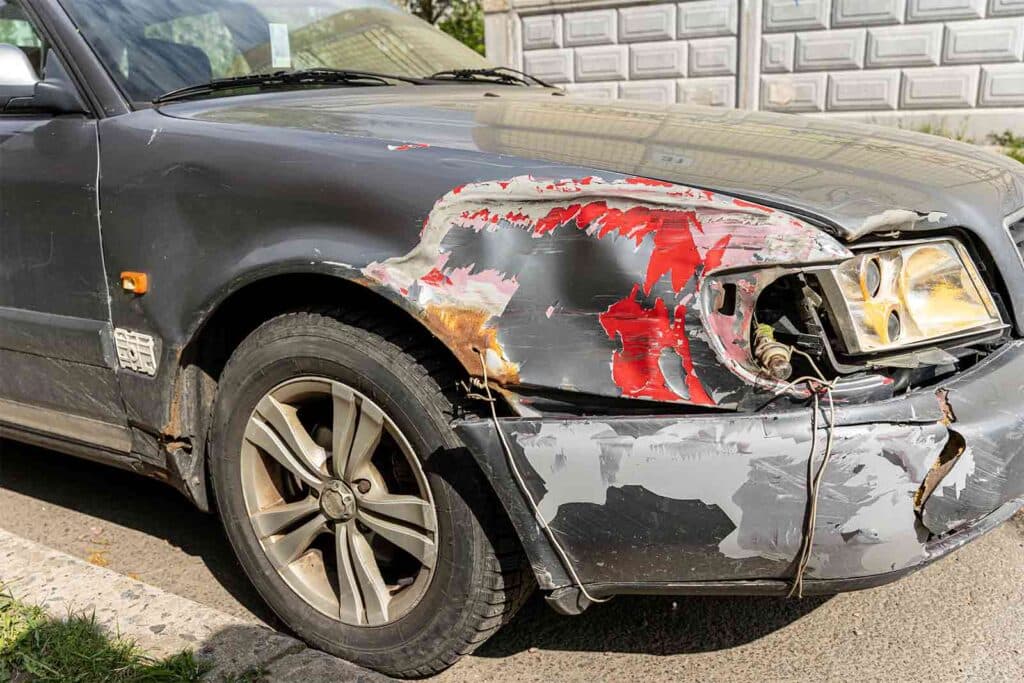 A car with accident damage to the front quarter panel