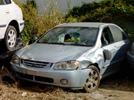 An abandoned scrap car with flat tyres awaiting collection