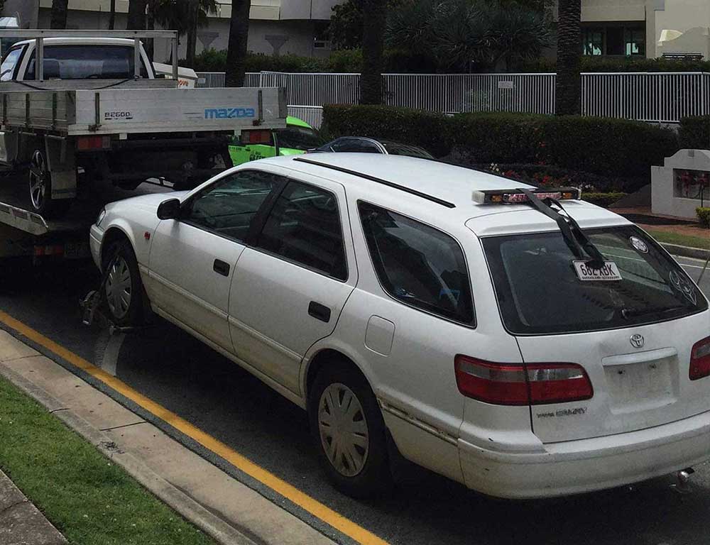 An abandoned scrap car with flat tyres awaiting collection