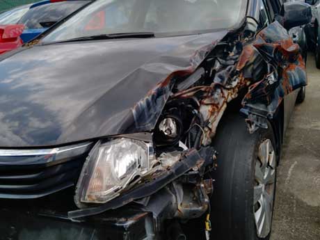 A car with a crumpled front end after a collision
